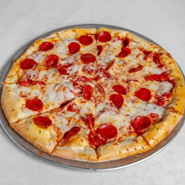 A whole pepperoni pizza, cut into slices, on a metal pan.