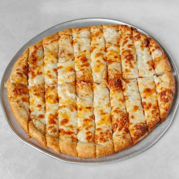 Cheesy breadsticks, cut into strips, on a round metal pizza pan at Picasso's Sports Café.